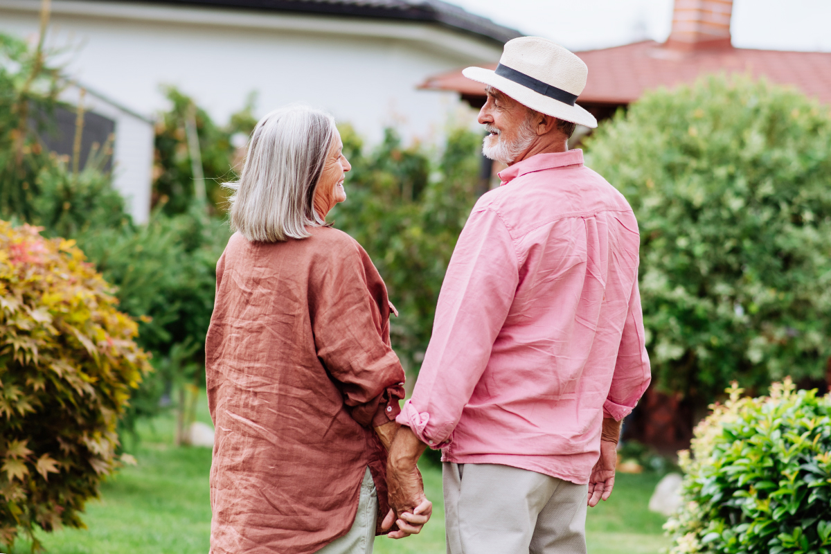 Couple de personnes âgées se tenant la main dans le jardin